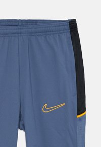 Nike trening shorts i lys blå med svarte nettingpaneler på sidene og gul logo. Har elastisk liv og glatt, lett materiale.