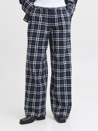 Calças largas em xadrez nas cores azul-marinho, branco e preto, com padrão quadriculado, cintura elástica e bolsos laterais.