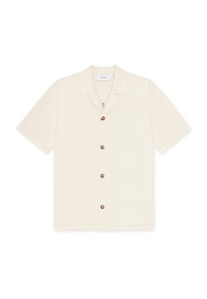 Chemise à manches courtes en tissu beige clair avec une patte de boutonnage et un col pointu. Dotée de boutons marron et d'une coupe décontractée.