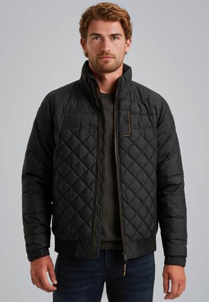 Veste matelassée noire avec un col montant, fermeture éclair à l'avant et détails de couture apparente. Présente des poignets côtelés et une coupe légèrement raccourcie.