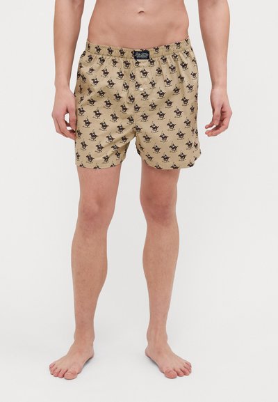Khaki boxer šortky s elastickým pasem, na kterých je opakovaný kreslený vzor. Materiál se zdá být hladký a má lehký design.