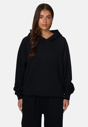 Schwarzer Hoodie mit einer Vordertasche, Raglanärmeln und einem dezenten Logo. Der Stoff wirkt weich, hat einen entspannten Schnitt und gerippte Bündchen.