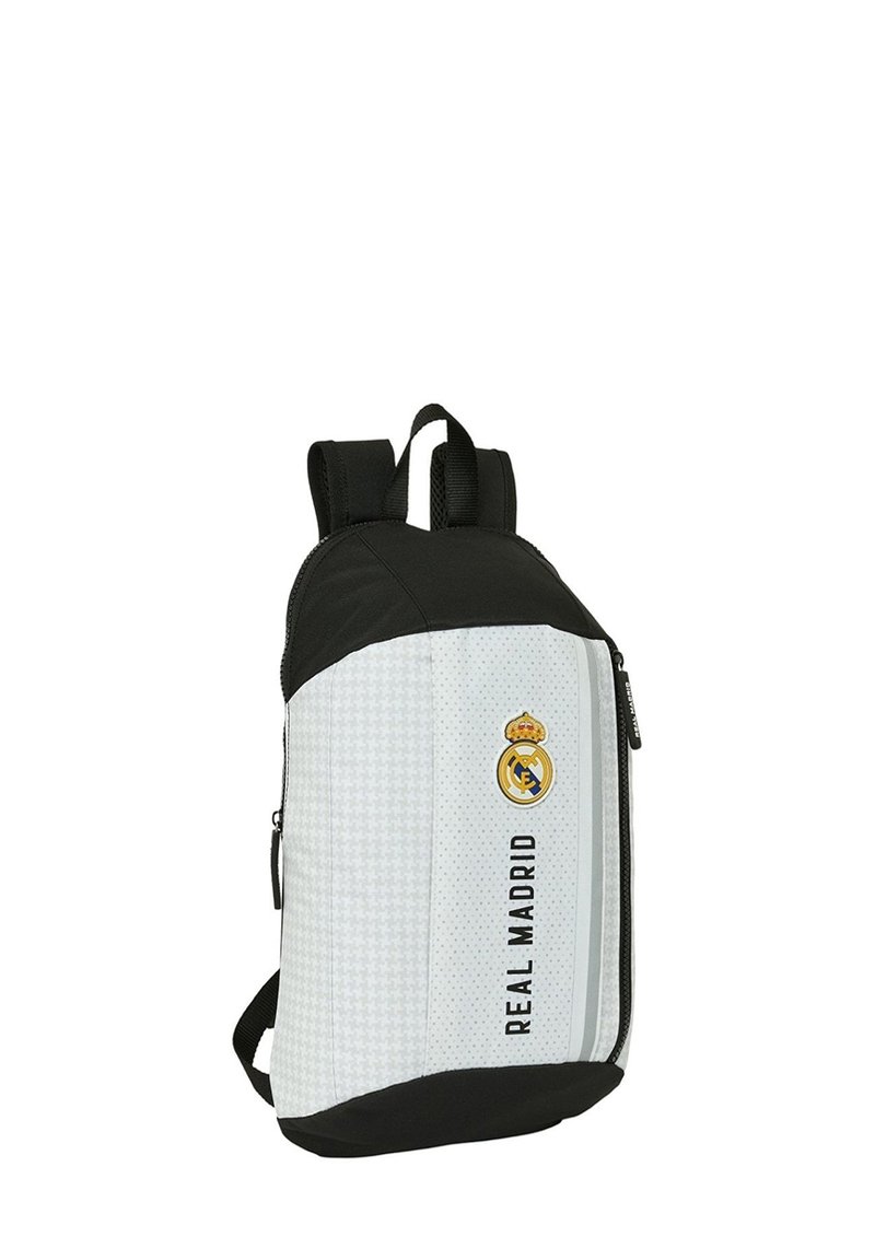 Zaino bianco e nero con una texture liscia, dotato del logo del Real Madrid, particolari neri e un compartimento con cerniera.