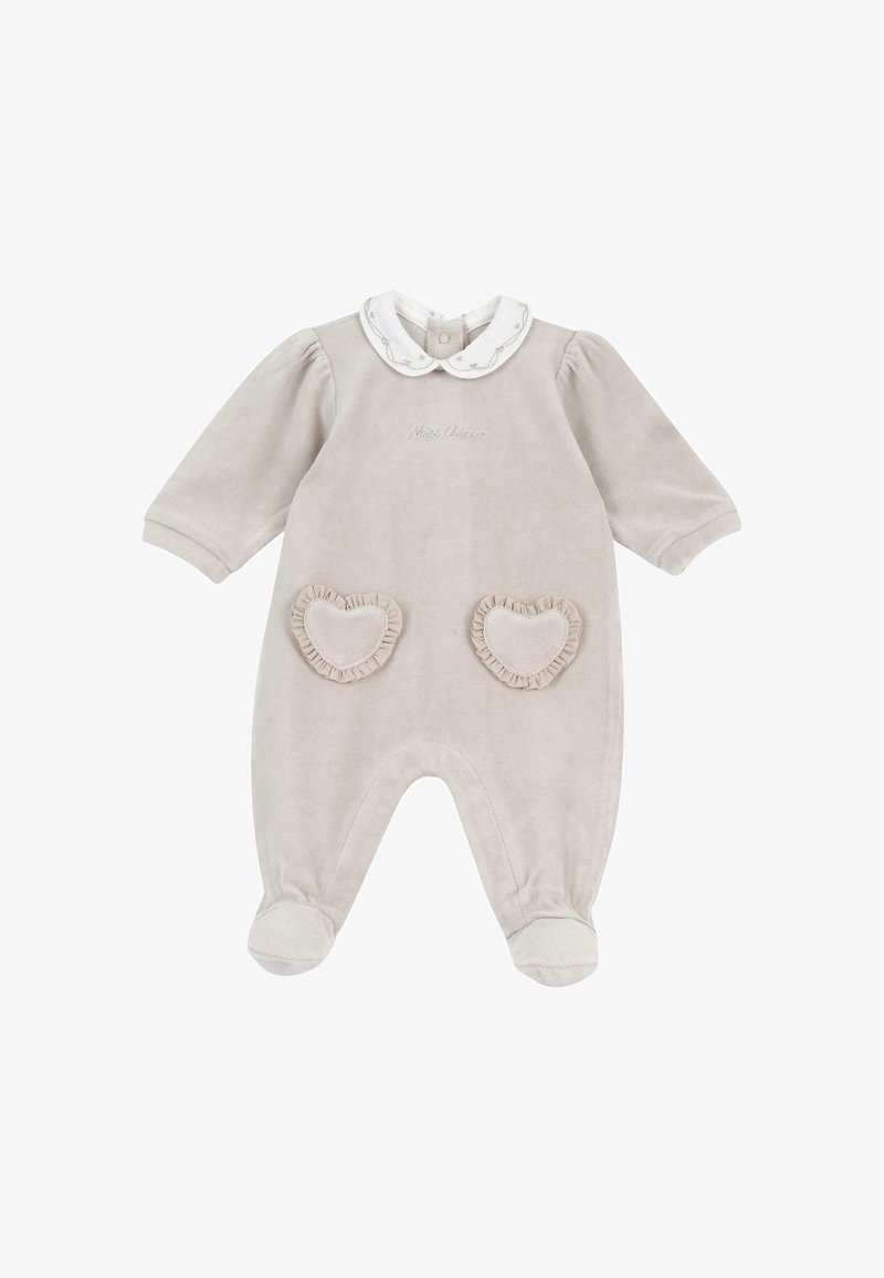 Combinaison beige à manches longues pour bébé avec col claudine blanc, poches en forme de cœur à volants à l'avant et pieds couverts.