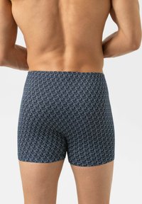 Boxers bleu marine avec un motif répétitif d'ours blancs. Fabriqués en matériau doux, ils disposent d'une ceinture élastique et d'une coupe ajustée.