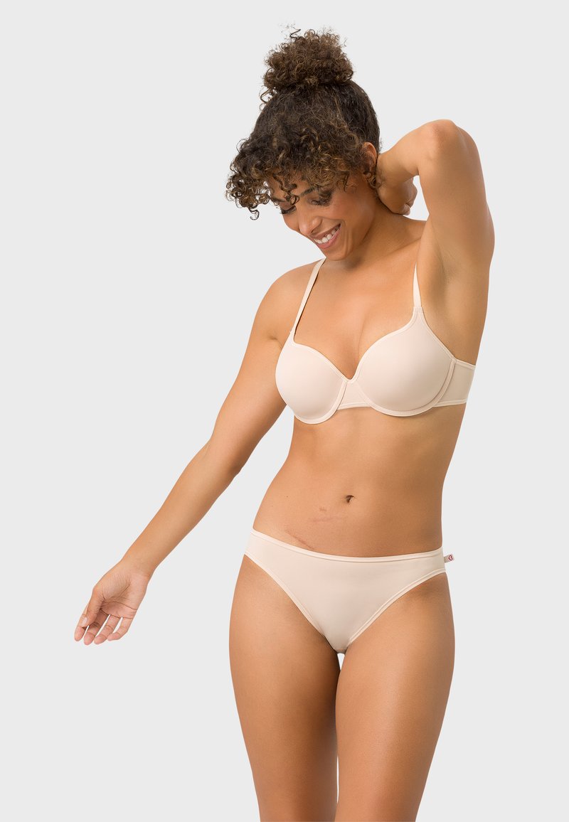 Beiger kabelloser BH und passende Slips aus glattem Stoff. Der BH hat eine gerundete Form und verstellbare Träger zur Unterstützung.