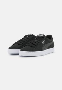 Mustad nahast spordijalatsid valge kummist tallaga, lame mustade nööridega ja reljeefse küljepaneeliga. PUMA logo keele ja külje peal.