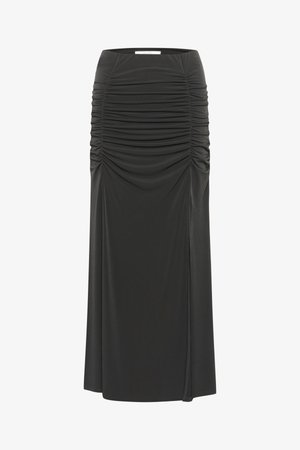 Jupe noire longue, en tissu extensible et lisse, avec une texture froncée sur les côtés et une fente sur le côté.