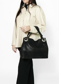 Borsa a tracolla nera intrecciata con grandi dettagli in metallo rotondi, presenta una superficie testurizzata e una forma morbida e arrotondata. Ha un manico robusto per un facile trasporto.