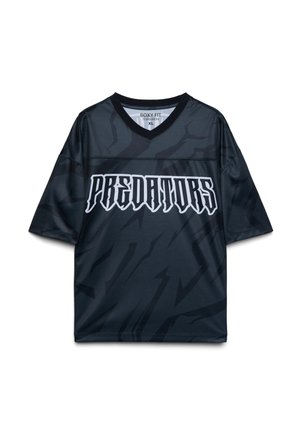 Maglia sportiva nera a maniche corte con la scritta "PREDATORS" in grassetto, carattere gotico bianco, e sottili motivi astratti scuri. Taglia XL, vestibilità ampia.