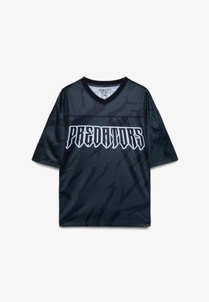 Maglia sportiva nera a maniche corte con la scritta "PREDATORS" in grassetto, carattere gotico bianco, e sottili motivi astratti scuri. Taglia XL, vestibilità ampia.