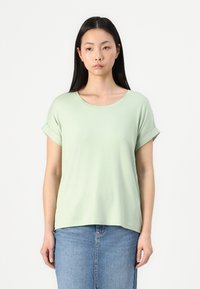 Hellgrünes T-Shirt mit kurzen Ärmeln und Rundhalsausschnitt, aus weichem Stoff gefertigt, mit umgeschlagenen Bündchen und einem lässigen Schnitt. Freizeitstil.