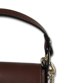 Bruine leren handtas met een textuurafwerking, een zwarte strap en gouden hardware accenten, waaronder een kettingbevestiging.