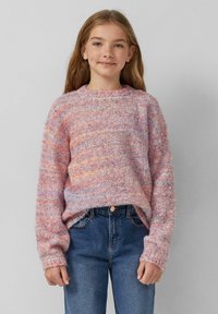 Sweter dzianinowy w pastelowych odcieniach różu, fioletu i pomarańczy. Posiada okrągły dekolt i luźny krój z prążkowanymi mankietami. Połączony z niebieskimi dżinsami.