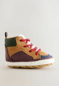 Hochfront-Sneaker für Kleinkinder mit braunen, lila und grünen Paneelen, roten Schnürsenkeln, einer weißen, felligen Zunge und einer weißen Gummisohle vor einem neutralen Hintergrund.