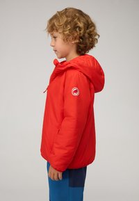 Giacca puffer rossa con cappuccio, dotata di una toppa con logo sulla manica sinistra. Texture liscia, chiusura con zip e polsini elasticizzati.