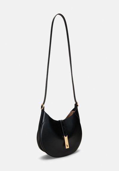 Bolso de hombro de cuero negro con forma redondeada, acentuado con herrajes dorados y una correa desmontable. Presenta una textura suave y un diseño minimalista.