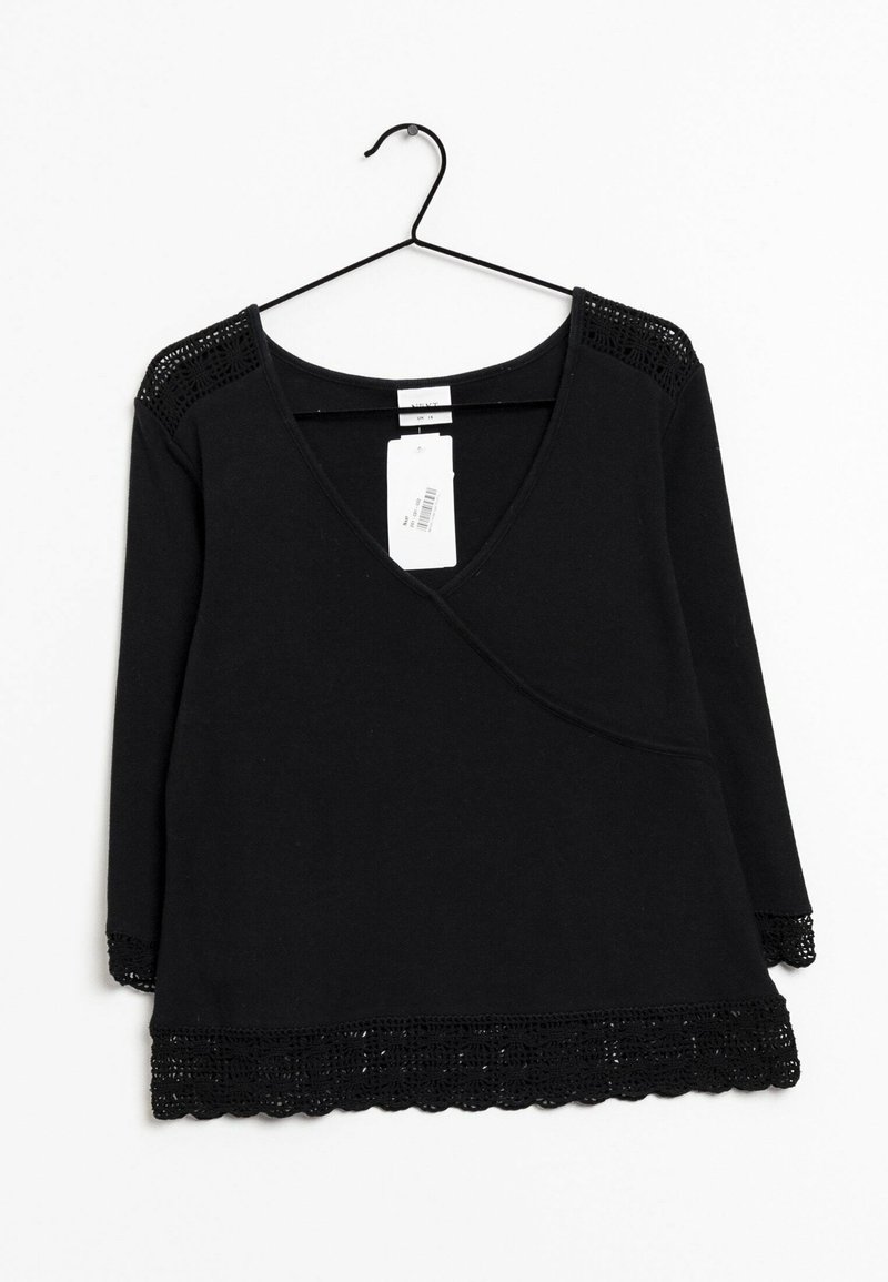 Sort langærmet top med v-hals, der har blondedetaljer ved skuldrene og bølget kant. Etiketten er fastgjort foran.