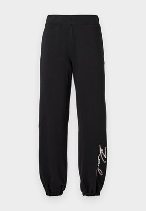 Black sweatpants with an elasticated waist and cuffs, featuring a decorative embroidered detail in silver and red on the left leg.