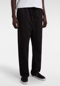 Black trousers made of lightweight fabric, featuring an elastic waistband with drawstring, and a relaxed fit with straight legs.