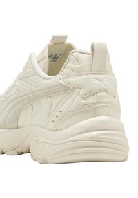 Weiße Leder-Sneaker mit strukturierten Akzenten, gepolstertem Schaft und Gummisohle. Mit dem Puma-Logo in dezentem Weiß an der Ferse.
