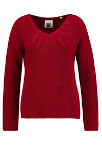 Rode gebreide trui met lange mouwen, V-hals, geribbelde textuur en details aan de zijkanten. Label zichtbaar aan de binnenkant van de halslijn.