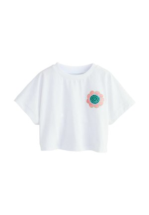 Fehér, rövid ujjú, derékig érő felső kerek nyakkivágással, bal oldalon apró rózsaszín virággal, amelyen kék spirál minta látható.