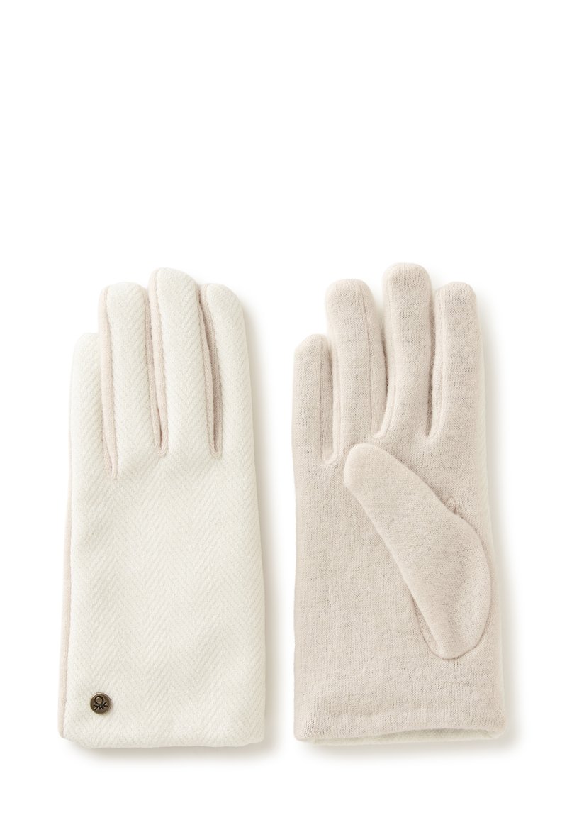 Ein Paar hellbeige Wollhandschuhe, einer zeigt die Rückseite mit Zickzackmuster und Metall-Logo, der andere zeigt die schlichte Handfläche.