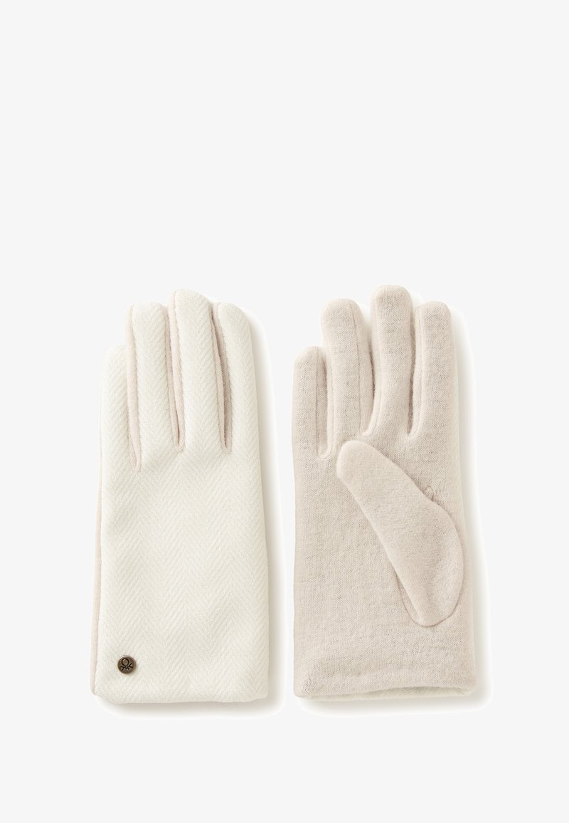 Ein Paar hellbeige Wollhandschuhe, einer zeigt die Rückseite mit Zickzackmuster und Metall-Logo, der andere zeigt die schlichte Handfläche.