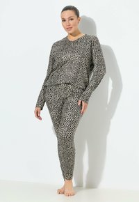 Set di abbigliamento lounge con stampa leopardata in beige e nero, composto da un top a maniche lunghe e leggings aderenti con texture liscia.
