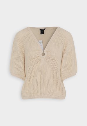 Top in maglia beige con scollo a V, maniche corte e un accento circolare al centro. Presenta un motivo a coste testurizzato su tutta la superficie.