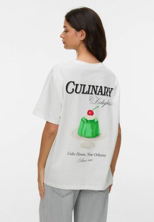 Kobieta o ciemnych włosach w białej koszulce prezentująca zielony deser z wiśnią i tekstem o Culinary Delights, Cake House, New Orleans.