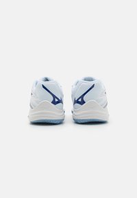 Chaussures de sport blanches avec des accents bleus, tige en maille, col rembourré et semelle extérieure texturée. Présente un logo sur le talon et un design sur la semelle intermédiaire.
