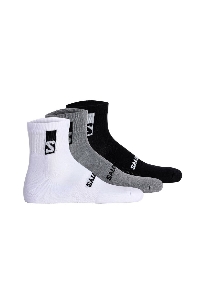 Tres pares de calcetines tobilleros en blanco, gris y negro, con puño acanalado y logo prominente. Hechos de una tela suave y elástica.