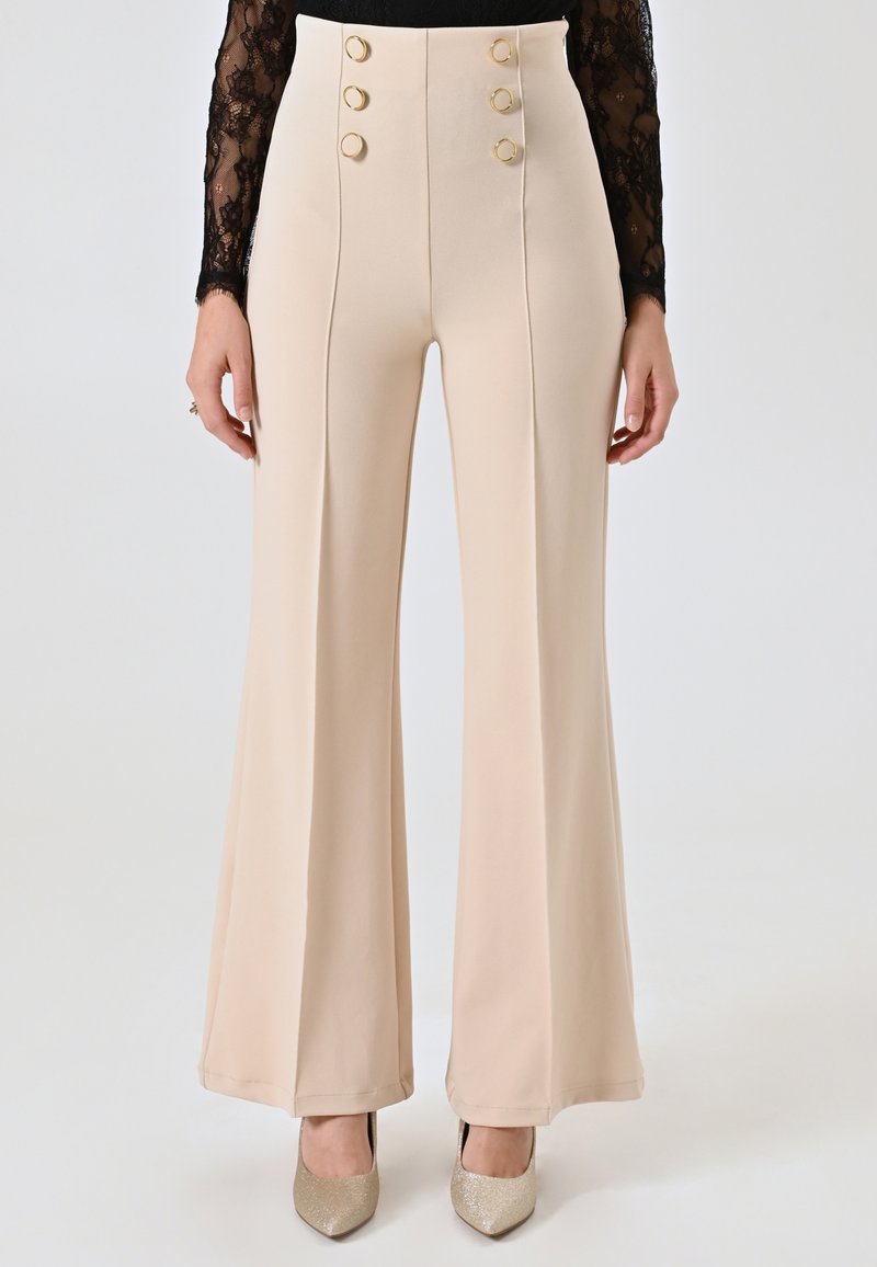 Beige high-waisted broek van een soepele stof met uitlopende pijpen, voorzien van vier goudkleurige knoopsaccenten aan de voorkant en verticale naden.