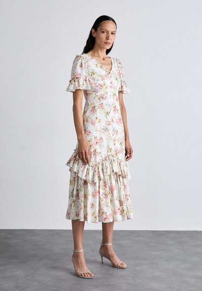 Abito lungo floreale bianco con motivi rosa e verdi. Presenta maniche a volant e orlo ondulato, realizzato in tessuto leggero, con vita aderente.