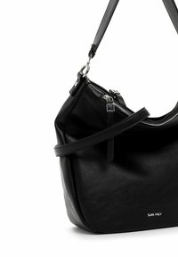 Sac à main en cuir noir avec une forme compacte, dotée d'une fermeture éclair en argent, d'une bandoulière réglable et d'un logo de marque subtil sur le côté.