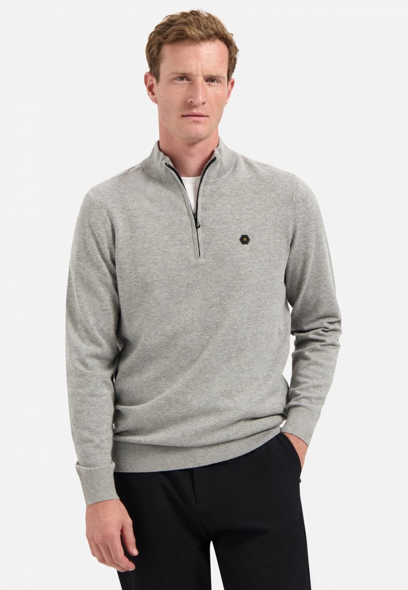 Grauer Pullover mit Reißverschluss und weichem Stoff, der ein tailliertes Design, gerippte Bündchen und ein kleines Sechseck-Logo auf der Brust aufweist.