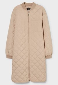 Ljusbeige kviltad lång kappa med ribbad krage, framsidan med dragkedja, bröstficka och tryckknappar i fållen. Mjuk textur genom hela plagget.