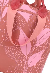 Bolso tote rosa y marrón con un patrón floral, con asas de tela rosa y acentos en rosa claro. Texto "fritzi" en un lado.