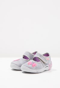 Szare buty z materiału o błyszczącej powierzchni, z różowymi wzorami motyli i kwiatów na przodzie oraz fioletowym wykończeniem wewnętrznym. Zapięcie na rzep.