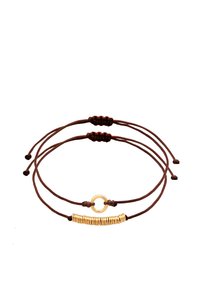 Bracciale in corda marrone con due fili regolabili. Un filo presenta un accento circolare dorato; l'altro ha perline a molla dorate.