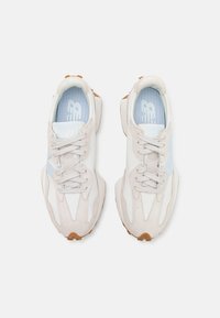 Light beige and white athletic shoes featuring a suede and mesh upper, lace closures, and a rubber outsole with a textured grip.