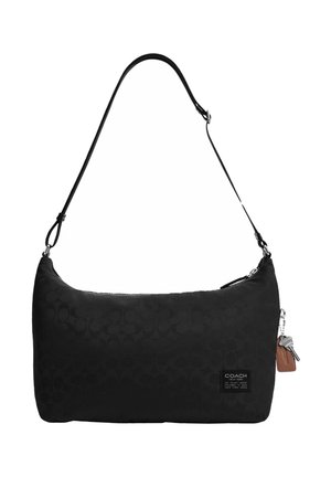 Sac bandoulière noir de Coach avec un motif monogramme subtil, bandoulière ajustable, fermeture éclair et petites étiquettes porte-clés en cuir attachées.