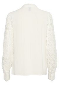 White blouse featuring long sleeves with intricate lace detailing, a smooth body, and a rounded collar. Soft fabric with a relaxed fit.