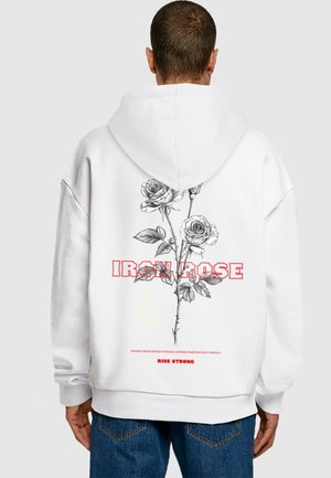 White hooded sweatshirt featuring a black and white rose illustration with red text "IRON ROSE" and "RISE STRONG" on the back.