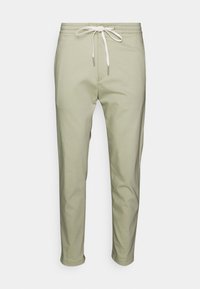 Dehnbare, leichte joggerhosen in olivgrün mit einem Kordelzugbund, schmal zulaufenden Beinen und einer seitlichen Tasche. Glatte Textur, lässiges Design.