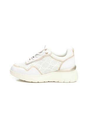 Zapatilla blanca con parte superior de tela perforada, acentos metálicos y suela blanca gruesa. Presenta una punta redondeada y diseño con cordones.