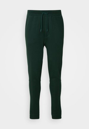 Dark green jogger pants in soft fabric with an elastic waistband, adjustable drawstring, and tapered cuffs. No visible patterns or hardware.