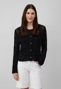 Zwarte gebreide cardigan met een textuur van kantpatroon, voorzien van een ronde halslijn, knoopsluiting en lange mouwen, gedragen over een zwarte top.